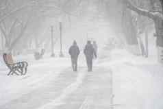 白雪覆盖的路人风暴暴雪降雪冬天坏天气城市极端的冬天天气条件北人走街道重降雪