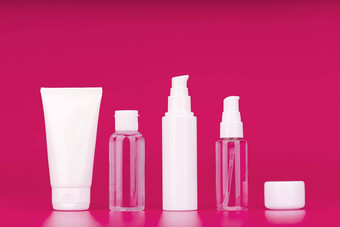 集化妆品产品每天皮肤例程黑暗粉红色的背景未打上烙印的化妆品容器行