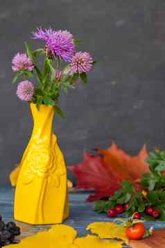 花束紫色的花黄色的花瓶黑暗背景
