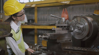 专业机械工程师操作女人穿统一的护目镜<strong>安全工作</strong>车间金属车床工业