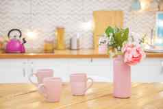 粉红色的花瓶花杯子茶表格光厨房