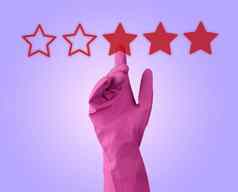 红色的评级星星手粉红色的橡胶手套淡紫色背景