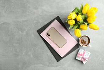 美丽的郁金香花瓶智能手机配件灰色的背景前视图