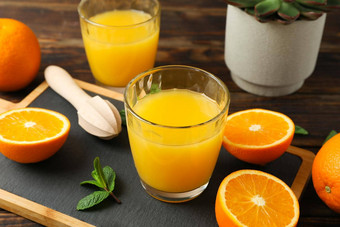 切割董事会橙色汁木榨汁机薄荷橙色小管多汁的植物木表格特写镜头新鲜的自然喝水果