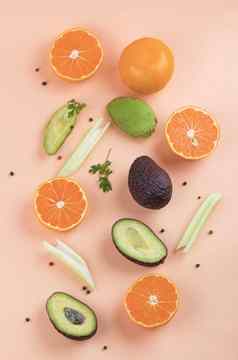 有创意的夏天模式使橙子芹菜鳄梨橙色背景水果最小的概念平躺