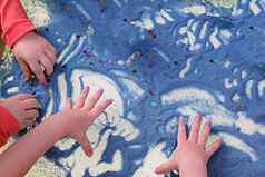 儿童手触碰蓝色的沙子白色表格沙子治疗发展细电动机技能