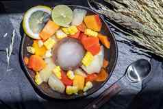 热带新鲜的水果沙拉服务玉米黑色的陶瓷碗
