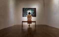 回来视图年轻的亚洲女人坐着板凳上感兴趣照片显示白色墙艺术画廊展览大厅