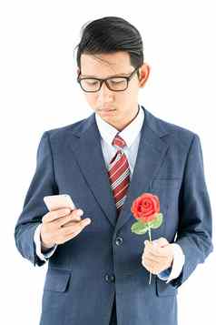 商人西装持有智能手机红色的玫瑰