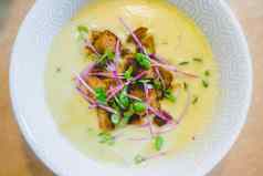 健康的新鲜的自制的西兰花汤油炸面包丁萝卜豆芽服务白色陶瓷碗
