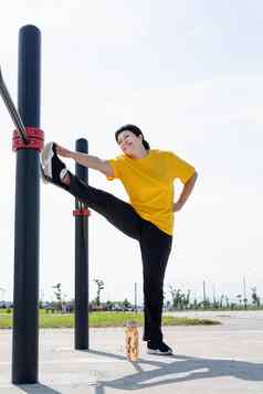 高级女人伸展运动腿在户外体育地面