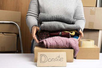 女人灰色的毛衣包装衣服盒子概念援助<strong>志愿服务</strong>