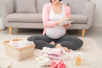 快乐怀孕了女人检查列表的事情未出生的婴儿首页地板上