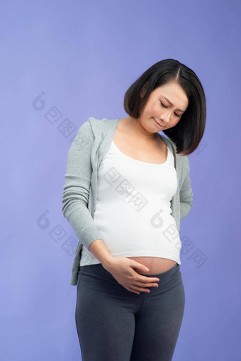 图片伤心怀孕了女人摆姿势孤立的淡紫色墙