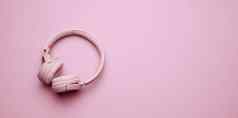 粉红色的无线耳机粉红色的背景横幅前视图现代小工具