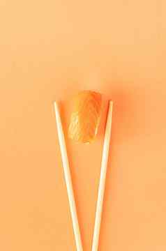 寿司大马哈鱼筷子孤立的橙色背景