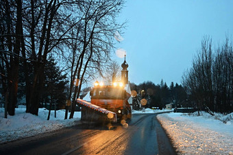 前面视图扫雪机服务卡车铺砂机车传播盐路维护道路冬天山