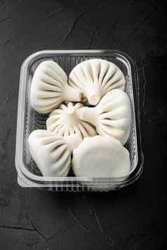 路面曼蒂饺子受欢迎的亚洲菜塑料托盘黑色的石头背景