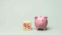 陶瓷粉红色的小猪银行木多维数据集百分比灰色的背景概念增加收入银行账户
