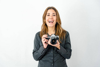 工作室拍摄微笑快乐年轻的女人持有古董照片相机看摄影师白色背景复制空间概念激情成像历史经典摄影