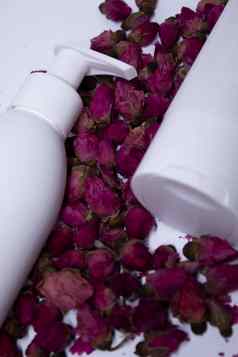 白色洗发水瓶标签桩粉红色的玫瑰身体护理美概念复制空间
