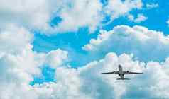 商业航空公司飞行蓝色的天空白色毛茸茸的云视图飞机飞行乘客飞机着陆飞行假期旅行在国外空气运输