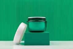 绿色打开化妆品Jar讲台上绿色背景概念奢侈品有机化妆品