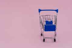 购物车孤立的粉红色的背景蓝色的购物车在线购物概念