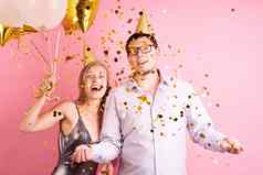 快乐笑夫妇庆祝生日聚会，派对持有金气球礼物盒子扔金五彩纸屑