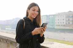 年轻的女人聊天应用程序移动电话参观欧洲小镇旅行女旅游导航地图智能手机城市河