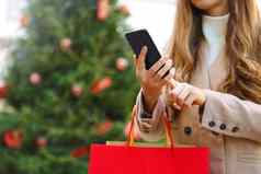 购物者女人聪明的电话购物在线携带袋圣诞节时间