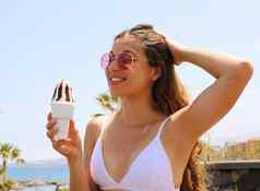美丽的女孩太阳镜吃冰奶油tenerife海滩夏天假期