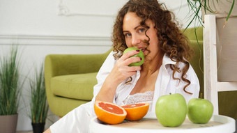 年轻的女人吃绿色苹果首页健康的营养饮食食物概念