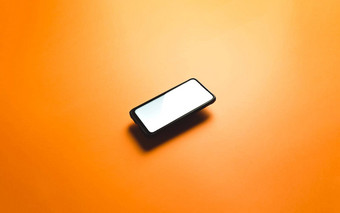 简约模拟平图像设计浮动移动电话复制空间白色小石子写平橙色背景