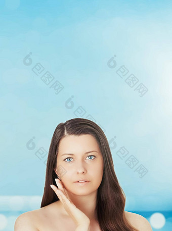 护肤品太阳保护夏天肖像美丽的年轻的晒黑了女人蓝色的海天空背景美健康旅行概念