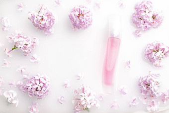 粉红色的香水瓶淡紫色分支白色背景概念广告香水瓶香水文本花芳香疗法布局