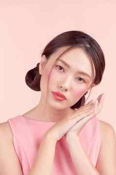 美丽的亚洲女孩专业化妆时尚的发型孤立的粉红色的化妆品化妆