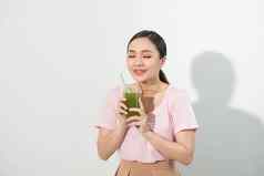 绿色年轻的美丽的女人享受健康的生水果蔬菜汁工作室拍摄