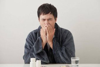 年轻的生病的生病了男人。沙发持有<strong>组织</strong>清洁流鼻涕的鼻子温度感觉坏受感染的冬天流感病毒流感流感健康护理概念