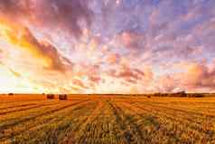 日落场干草堆秋天季节农村景观多云的天空背景阳光明媚的晚上