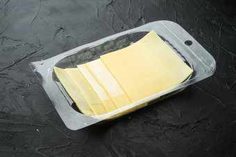 块切达干酪奶酪塑料包黑色的石头背景复制空间文本