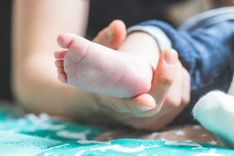 婴儿新生儿概念母亲的手持有新生儿婴儿脚