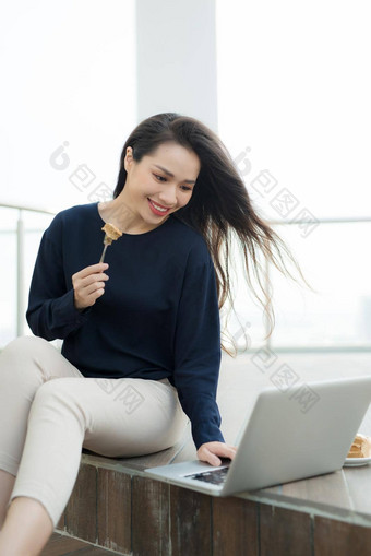 开销视图年轻的女人工作移动PC咖啡馆前视图拍摄女坐着表格杯咖啡浏览互联网