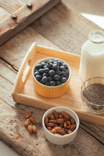 健康的素食主义者早餐瓶装牛奶传讲杏仁新鲜的水果浆果木表格背景复制空间清洁吃重量损失素食者生食物概念
