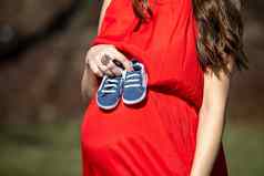 年轻的夫妇等待婴儿期待父母婴儿男孩鞋子概念准父母鞋子运动鞋父母预期婴儿妈妈爸爸未来婴儿鞋子
