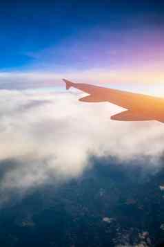 飞行旅行视图飞机窗口翼日落时间飞机翼地球云飞行天空飞机翼飞行