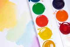 色彩斑斓的水彩刷中风前视图画笔调色板水彩油漆白色纸