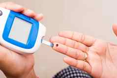 女人测量葡萄糖测试水平检查血手指glucometer