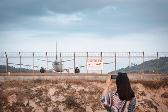 <strong>旅游</strong>女人捕捉照片飞机着陆跑道跟踪机场亚洲<strong>旅游</strong>女人有趣的摄影车辆飞机机场栅栏