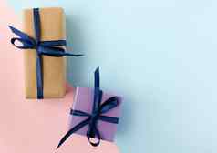 色彩斑斓的礼物盒子蓝色的丝带弓蓝色粉色背景复制空间
